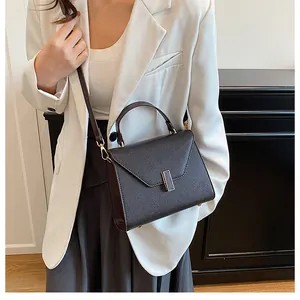 Detailed view of dark brown pebbled leather tote bag with gold metal clasp and top handle