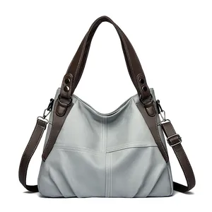Minimalist light blue pebbled leather tote bag with dark brown handles and shoulder strap