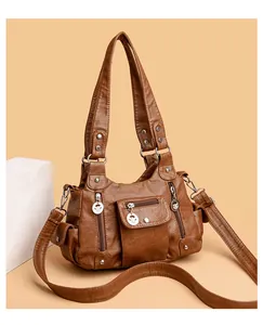 Detail of a brown vintage leather handbag with silver zippers and multi-pocket layout