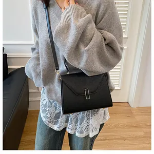 Detailed view of black litchi pattern leather crossbody bag with V-shaped flap