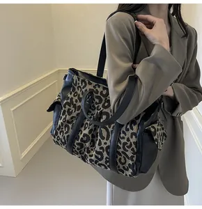 Detailed view of leopard print tote bag with side pockets and black leather accents