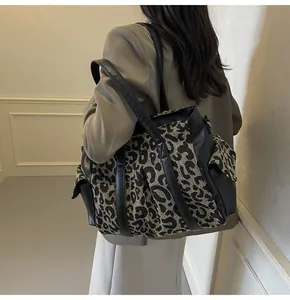 Detail of the leopard print tote bag featuring side flap pockets and sturdy black straps