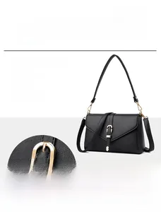 Detailed view of elegant black leather shoulder bag featuring a premium golden horseshoe buckle