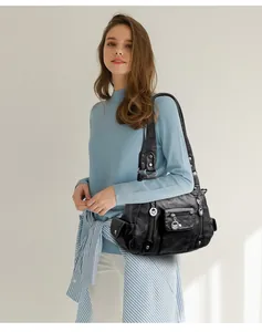 Close-up of black washed PU leather bag with multi-zipper pockets and silver hardware