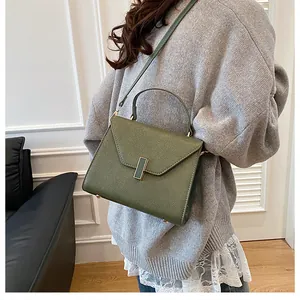 Detail of dark green lychee pattern leather tote bag with elegant golden metal clasp