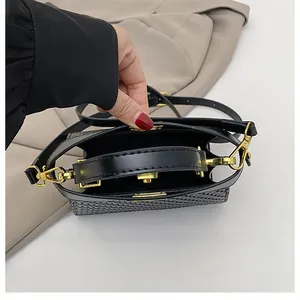 Detailed top view of black woven texture handbag showing golden hardware and interior lining