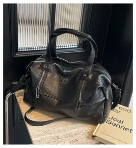 Detailed close-up of a black retro PU leather tote bag with metallic logo on a marble surface
