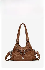 Vue détaillée d'un sac vintage marron avec motif matelassé et tirettes fleurs en métal