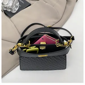 Top view of black woven crossbody bag showing interior capacity with wallet and glasses