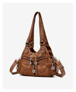 Détail du sac vintage en cuir marron avec zips métalliques floraux et multiples poches