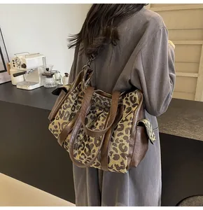 Detail of the leopard print canvas tote bag with brown leather handles and side pocket
