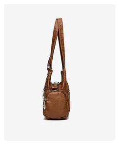 Vue latérale du sac vintage marron avec poches zippées multiples et pendentif feuille