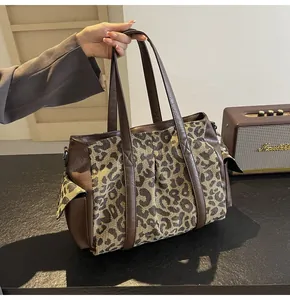 Detailed shot of leopard print canvas tote with brown leather trim and side pockets