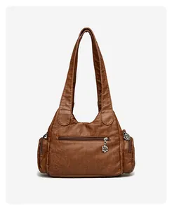 Détail de sac cabas en cuir souple marron avec breloques florales et fermetures