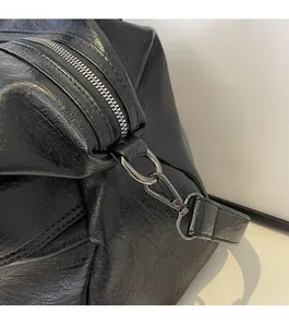 Close-up of gunmetal zipper and metallic clasp on black oil-wax texture tote bag