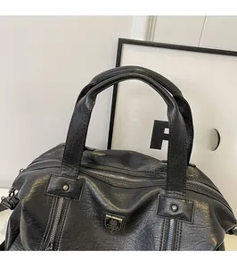 Detail of black PU leather tote with shield logo and silver metallic zipper closure