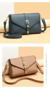 Detailed comparison of dark blue and camel leather crossbody bags with metal buckles