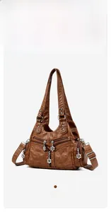 Détail du sac vintage en similicuir marron avec coutures losanges et pendentifs fleur