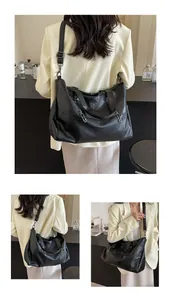 Detail view of black vintage tote bag with soft pleated texture and multi-zipper accents