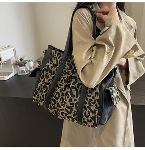 Macro view of leopard print jacquard canvas texture and black faux leather trim on tote bag