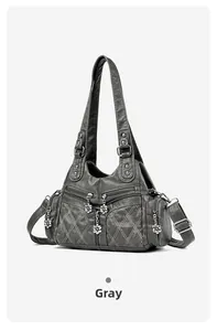 Détail du sac de moto gris en similicuir avec motif matelassé et breloque fleurie