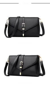 Detail of black pebbled leather crossbody bag with elegant gold U-shaped metal buckle