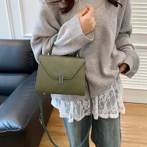 Classic dark green tote bag in pebbled faux leather with gold buckle detail and strap