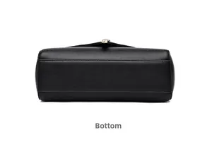 Detail view of the black leather bag bottom featuring precise stitching and gold metal clasp