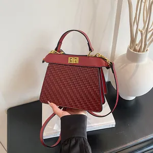 Deep red woven leather crossbody bag with golden twist lock and elegant handle