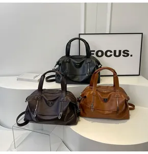 Three retro large-capacity tote bags in black, dark brown and tan on display