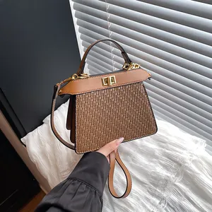 Brown woven leather handbag with metallic twist lock and top handle shown in a minimalist setting