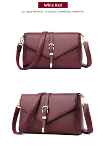 Detail view of wine red faux leather flap bag with gold tone metal buckle and textured finish