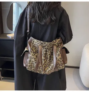 Detail of leopard print canvas tote bag with side pockets and brown leather straps