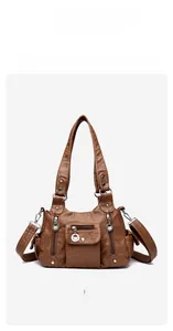Detailed close-up of brown vintage PU leather handbag with metal rings and zipper pockets