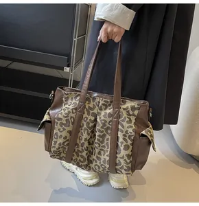 Detailed close-up of leopard print canvas tote bag with brown leather reinforced handles