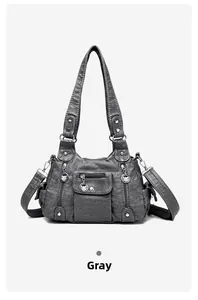 Detail view of multi-pocket grey faux leather handbag with silver metallic zippers