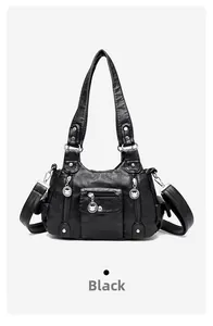 Detail of black vintage PU leather handbag showing zipper pockets and silver studs
