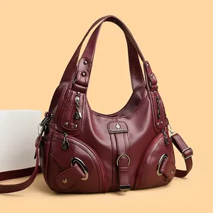 Stylish burgundy pebble leather dumpling tote bag with dual handles and metal logo plate