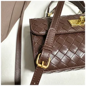 Dettaglio della borsa in pelle intrecciata marrone con chiusura a scatto dorata