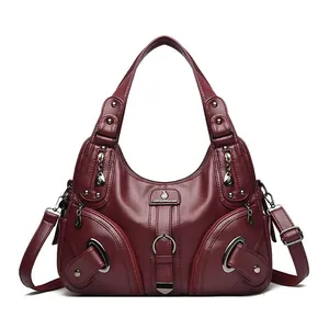Deep red pebbled leather tote bag with dual handles and adjustable shoulder strap