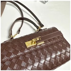 Dettaglio della borsa in pelle intrecciata marrone scuro con chiusura in metallo oro