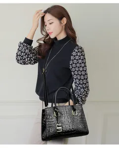 Detailed view of crocodile texture on a black handbag with elegant gold hardware