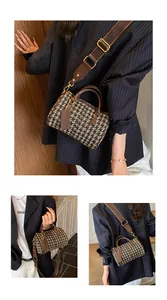 Detail of vintage checkerboard barrel bag with dark brown leather trim and shoulder strap