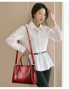 Vista dettagliata della borsa tote in pelle goffrata coccodrillo rosso su modella.