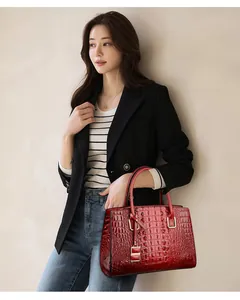 Detail of red crocodile pattern leather tote bag with gold metal hardware and S pendant