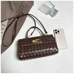Dettaglio della borsa intrecciata marrone scuro con chiusura a scatto dorata e tracolla
