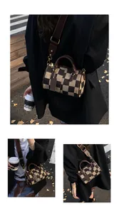 Detail of checkered Boston bag featuring adjustable brown strap and gold-tone hardware