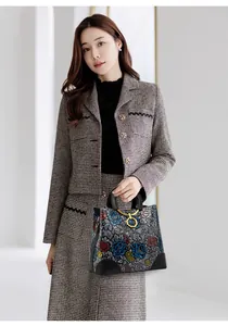 Detail of ethnic retro embossed handbag with colorful floral patterns and round handle