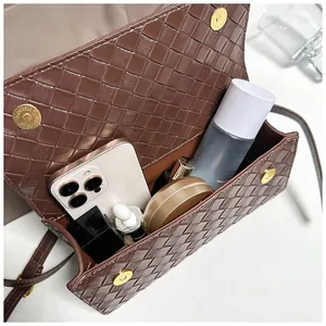 Vista interna della borsa in pelle intrecciata marrone con spazio per il cellulare