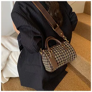 Detail of checkered canvas Boston bag with brown leather trim on a fashion model